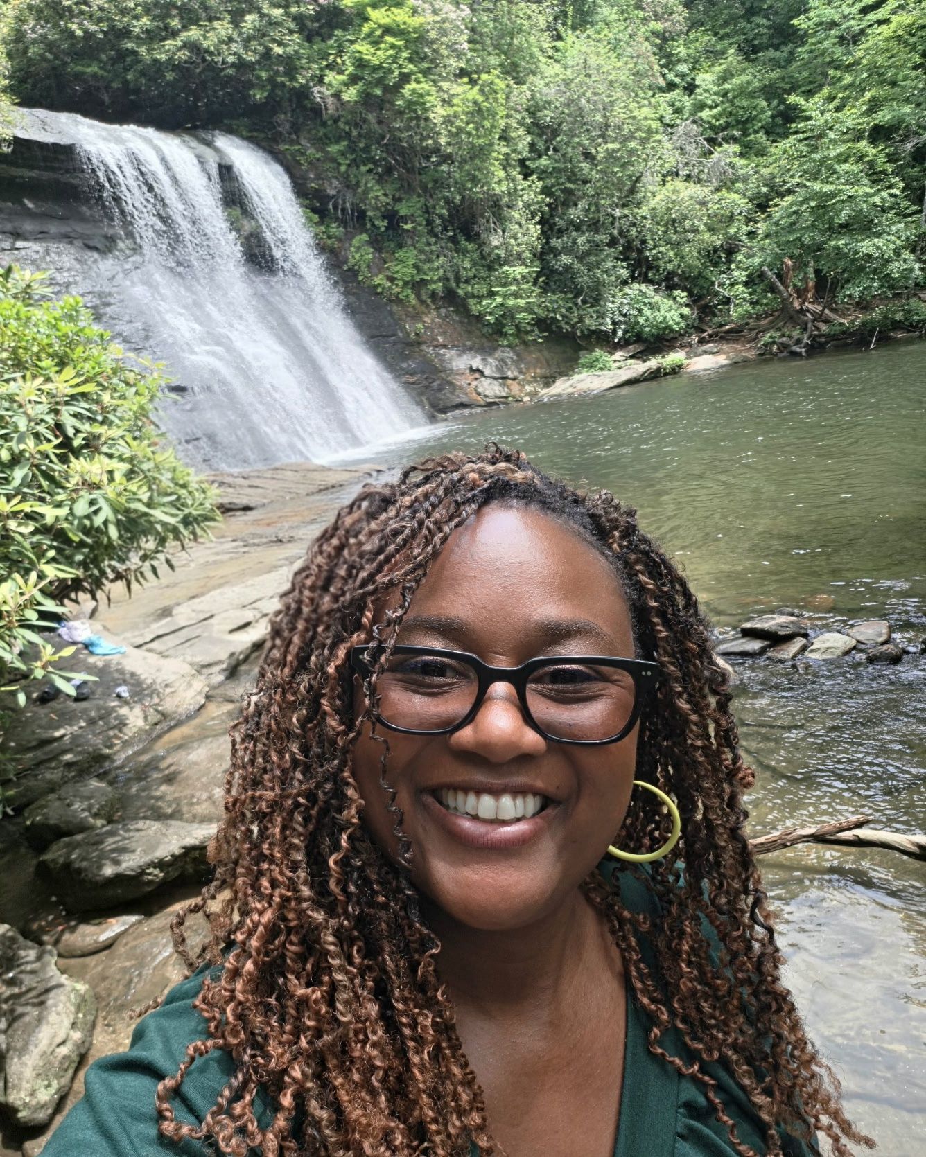 Lisa Walker, founder of Risal Systems, smiling in front of a waterfall in the North Georgia mountains